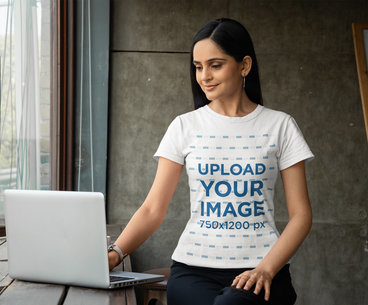 Gildan T-Shirt Mockup of a Happy Woman Checking a Laptop
