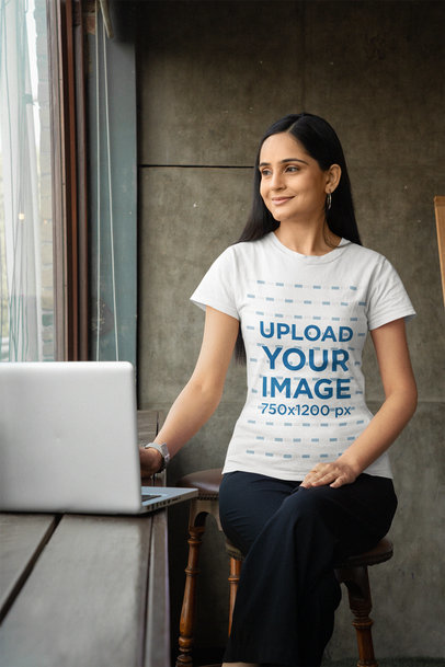 Gildan T-Shirt Mockup of a Smiling Woman Working on Her Laptop