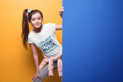 Girl with Ponytail Wearing a T-Shirt Mockup Coming Out of a Wall