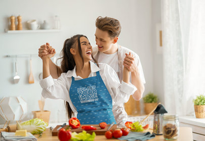 Apron Mockup Featuring a Woman Dancing With Her Partner While Cooking