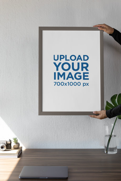 Mockup of a Person Holding an Art Print Against a Wall