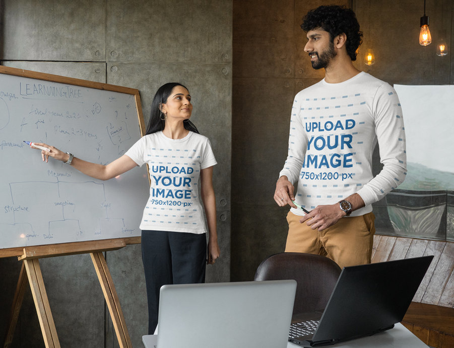 T-Shirt Mockup Featuring a Man and a Woman Using a Whiteboard at an Office