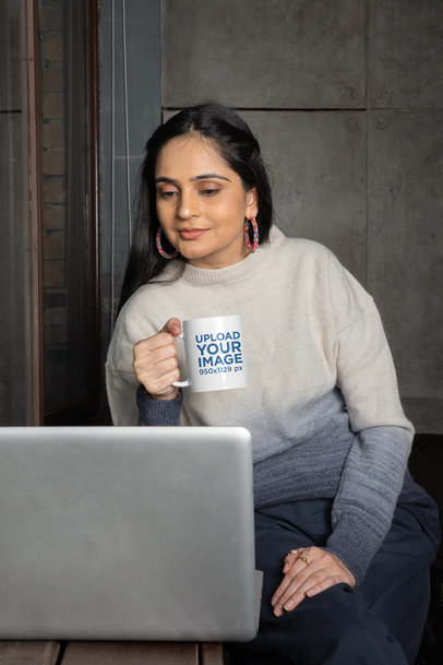 Coffee Mug Mockup Featuring a Smiling Woman Checking Her Laptop