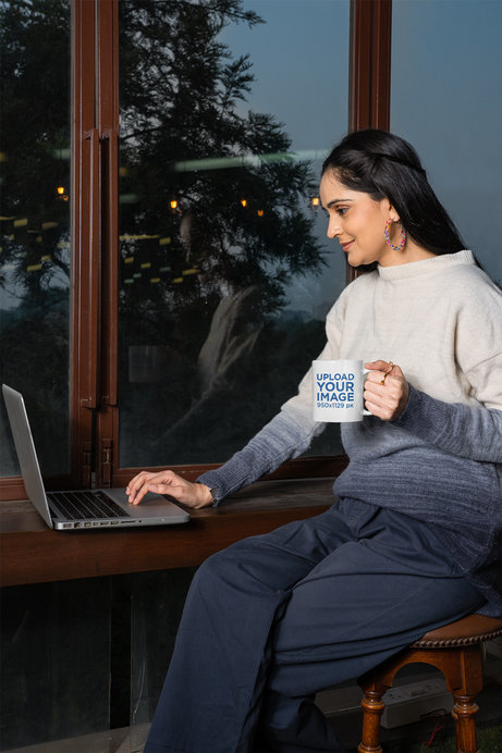 Mockup of a Smiling Woman Holding a Coffee Mug While Working
