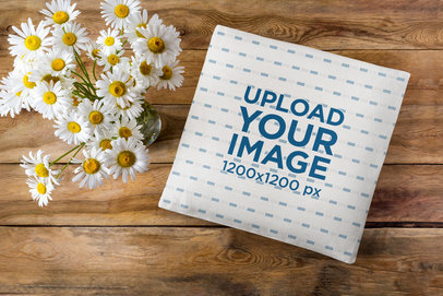 Sublimated Pillow Mockup Featuring a Wooden Surface and Decorative Flowers
