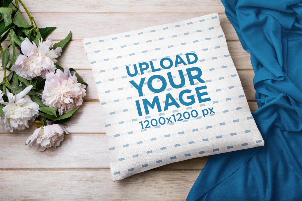 Square Pillow Mockup Featuring Decorative Flowers and a Wooden Surface