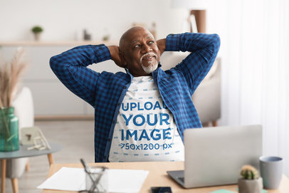 T-Shirt Mockup of a Senior Man Stretching at His Desk