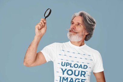 Round-Neck Tee Mockup of a Bearded Senior Man Holding a Magnifying Glass