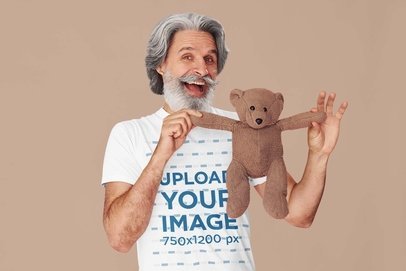 Round-Neck Tee Mockup of a Happy Elderly Man Holding a Teddy Bear