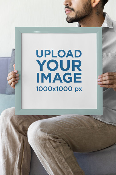 Mockup of a Bearded Tattooed Man Holding an Art Print