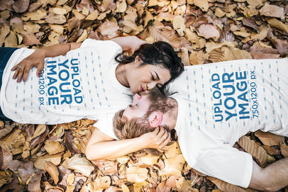 Round-Neck T-Shirt Mockup Featuring a Cute Couple Kissing and Lying on Autumn Leaves
