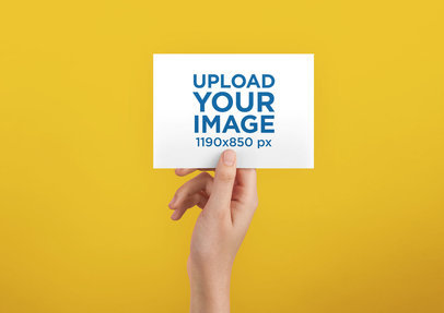 Horizontal Post Card Template Being Held Against a Solid Color Surface