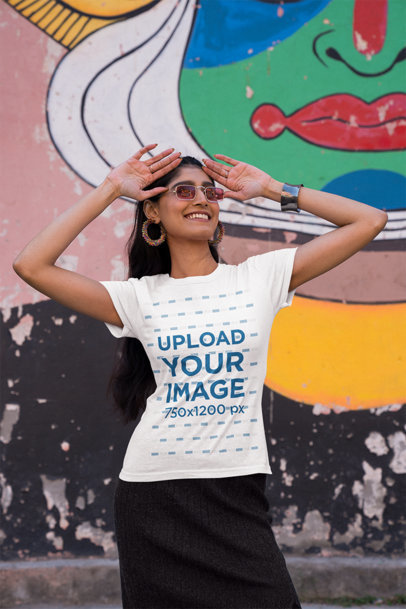 Gildan T-Shirt Mockup of a Woman with Sunglasses Posing by a Wall with Urban Art
