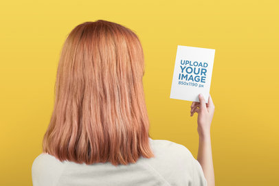 Postcard Mockup Being Held by a Woman Against a Solid Background