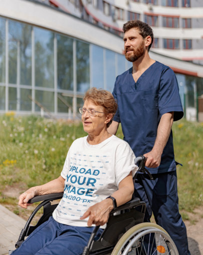 T-Shirt Mockup of a Smiling Senior Man Sitting in a Wheelchair
