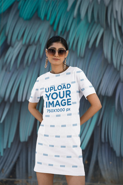 T-Shirt Dress Mockup Featuring a Woman Posing Against a Painted Wall