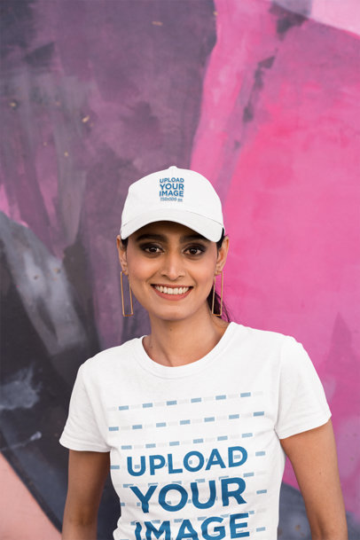 T-Shirt and Dat Hat Mockup Featuring a Smiling Woman Posing Against a Colorful Wall m31904