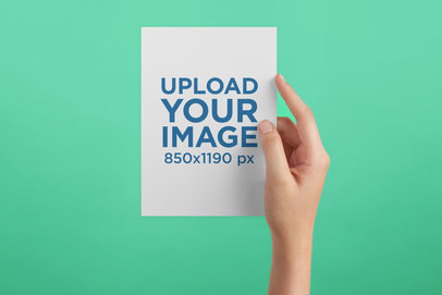 Postcard Mockup Being Held Against a Solid Color Surface