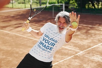 Round-Neck T-Shirt Mockup Featuring a Sporty Senior Man Catching a Tennis Ball