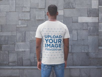 Back Shot T-Shirt Mockup of a Man Facing a Modern Stone Wall
