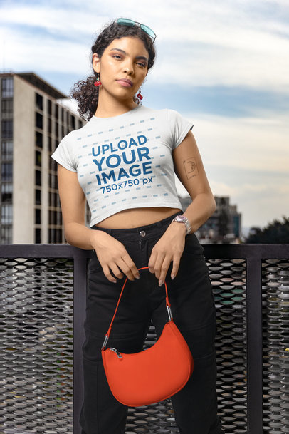 Gildan Crop Top Mockup Featuring a Serious Tattooed Woman Posing Against a Balcony