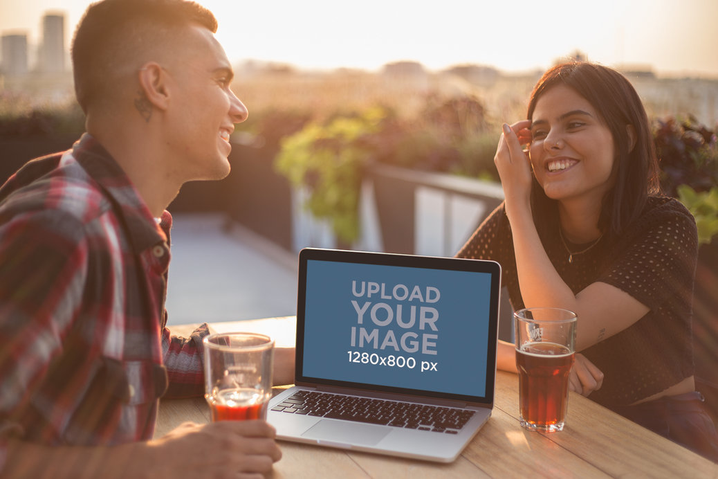 Man and Woman Laughing with a MacBook Mockup on the Table