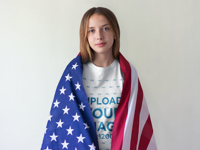 Girl Wearing a T-Shirt Mockup Carrying the American Flag on her Back