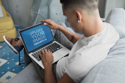 Man Using a MacBook Mockup Sitting on a Couch