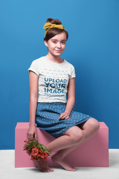 Smiling Girl Wearing a T-Shirt Mockup Holding a Flowers Bouquet while Sitting