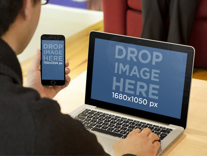 Mockup of a Man Working on a MacBook Pro and an iPhone