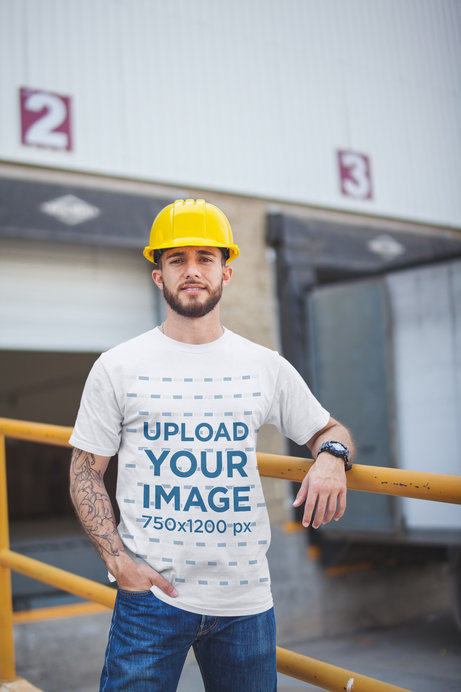 Mockup of a Tattooed Man Wearing a T-Shirt Outside the Warehouse
