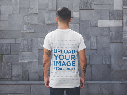 Back Shot Tshirt Mockup of a Man Facing a Modern Stone Wall