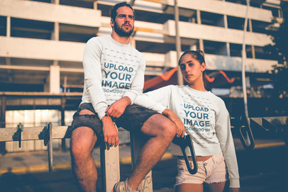 Hipster Couple Wearing Crewneck Sweaters Mockup Outside a Building in the Afternoon