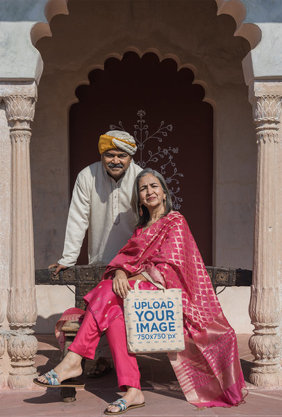 Tote Bag Mockup of a Couple Posing in Traditional Indian Attires in an Ancient Temple