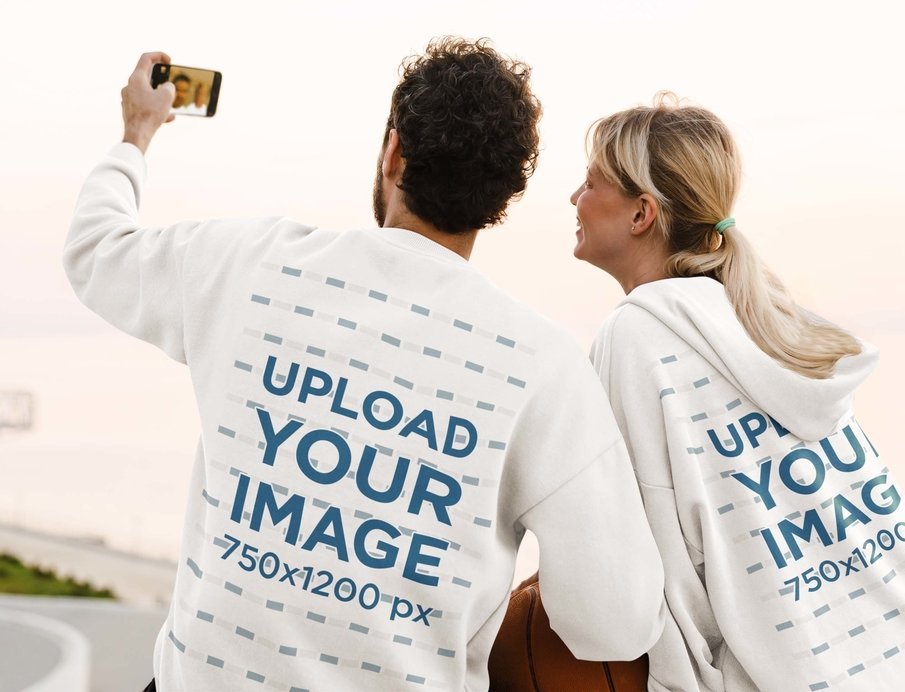 Back-View Sweatshirt and Hoodie Mockup Featuring a Couple Taking a Selfie