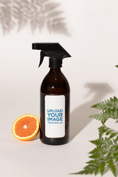 Label Mockup Featuring a Glass Spray Bottle and Half an Orange