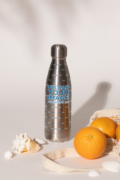 Mockup of an Aluminum Bottle Placed in an Aesthetic Setting With Oranges