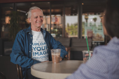 Happy Senior Man Wearing a T-Shirt Mockup Having a Frappuccino with a Friend