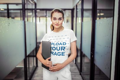 Woman Wearing a Tshirt Mockup Holding a Laptop in a Corridor at the Office