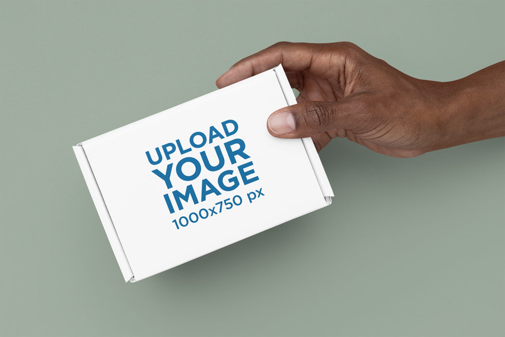 Mockup of a Man's Hand Holding a Box Against a Solid Surface