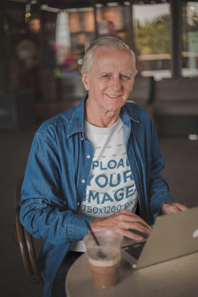 Happy Senior Man Wearing a Tshirt Mockup Working at a Coffee Shop