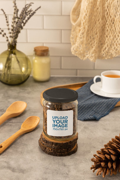 Mockup of a Glass Jar Placed on a Kitchen Table Next to Wooden Spoons
