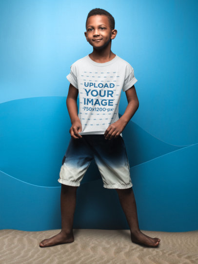 Kid Showing his T-Shirt Mockup Against a Blue Wall