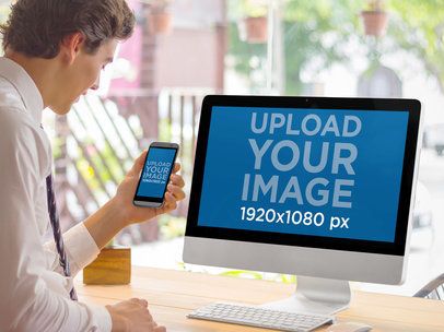 Mockup of a Man Using an Android Phone and an iMac