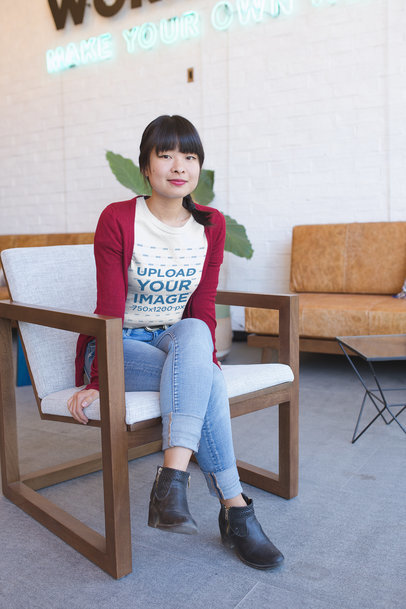 Asian Woman Wearing a Tshirt Mockup Sitting on an Armchair
