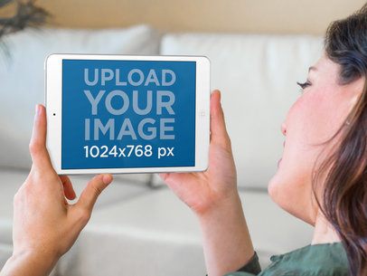 Mockup of a Woman Using an iPad Mini at Home