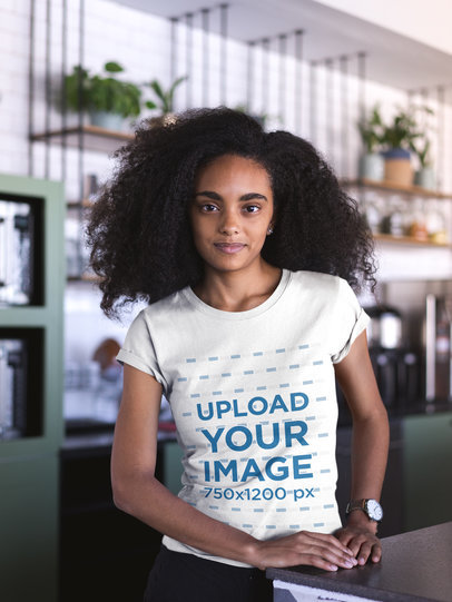 Mockup of a Woman with Curly Hair Wearing a T-Shirt at a Startup 