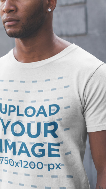 Closeup of a Man Wearing a Tshirt Mockup Against a Concrete Wall
