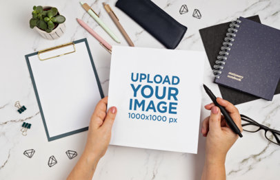Mockup of a Woman Holding a Pen and a Sketch Paper m32095 r-el2
