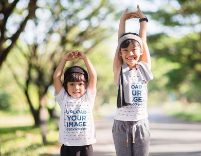 T-Shirt and Tank Top Mockup Featuring Two Little Sisters Posing in the Park